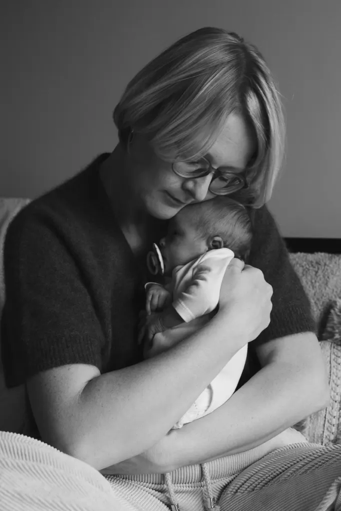 Zwart-witbeeld van een moeder die haar pasgeboren baby vasthoudt